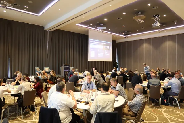The full room at the Org Design Summit 2026: round tables of participants facing the stage