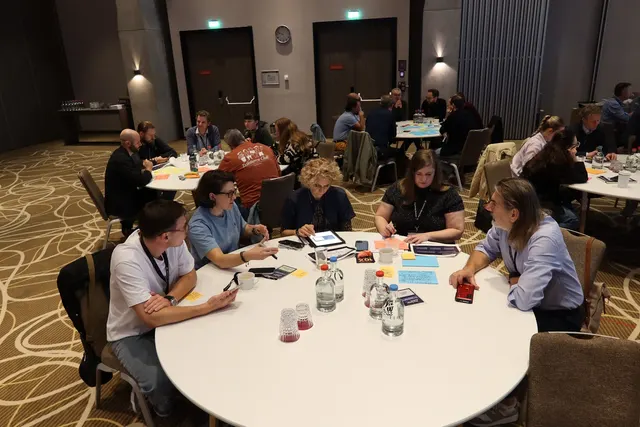 Participants working at a round table with cards and notes